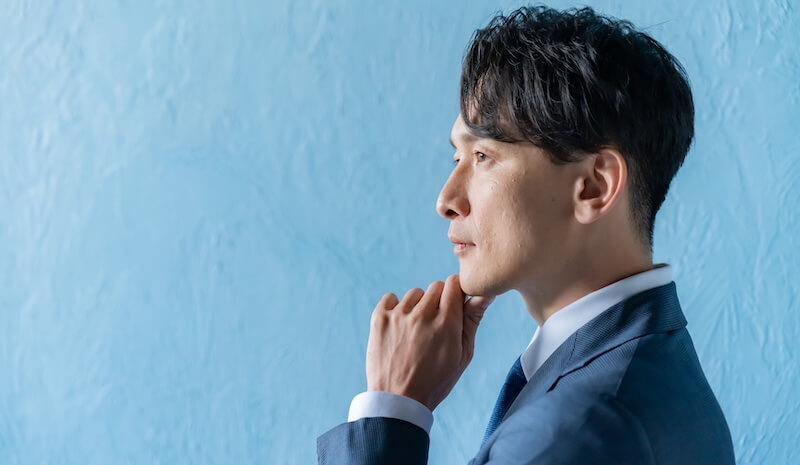 考えるスーツを着た男性