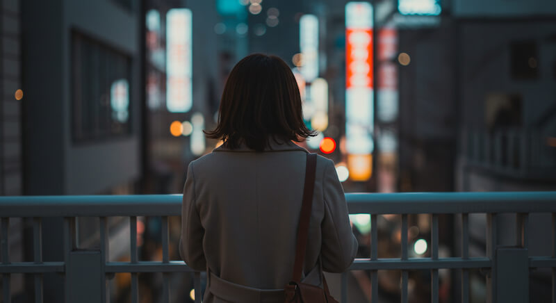 ぼんやりと街を見つめる女性