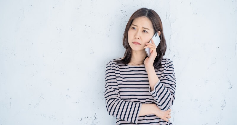 電話を掛ける困っている30代女性