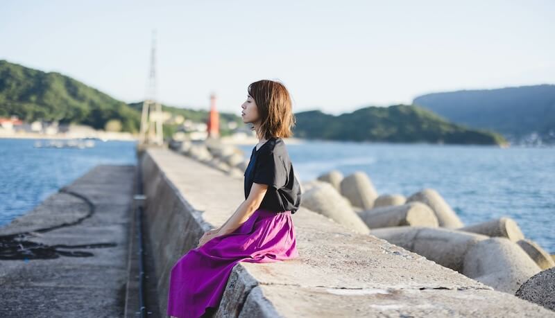 夕暮れの海の女性